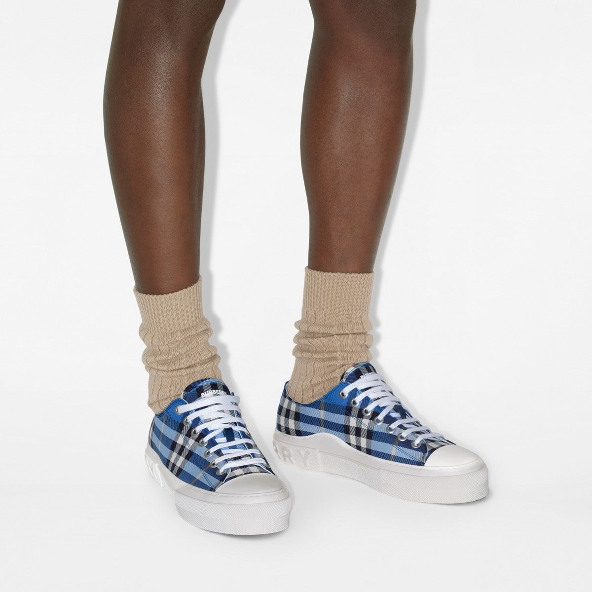 Blue plaid sneakers worn with beige socks, blue laces and white rubber sole