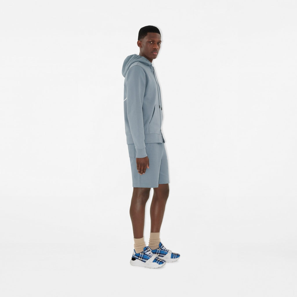 Burberry sneakers on model, blue plaid uppers with white laces and thick sole