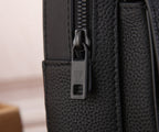 Men's Louis Vuitton mini sling bag close-up, metal buckle and LV charm on strap.
