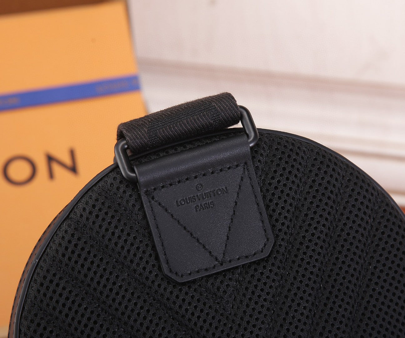 Black Louis Vuitton bag interior label patch on textured leather with strap tab