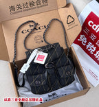 Coah bag denim crossbody with chain strap, front flap, metal ring and tags