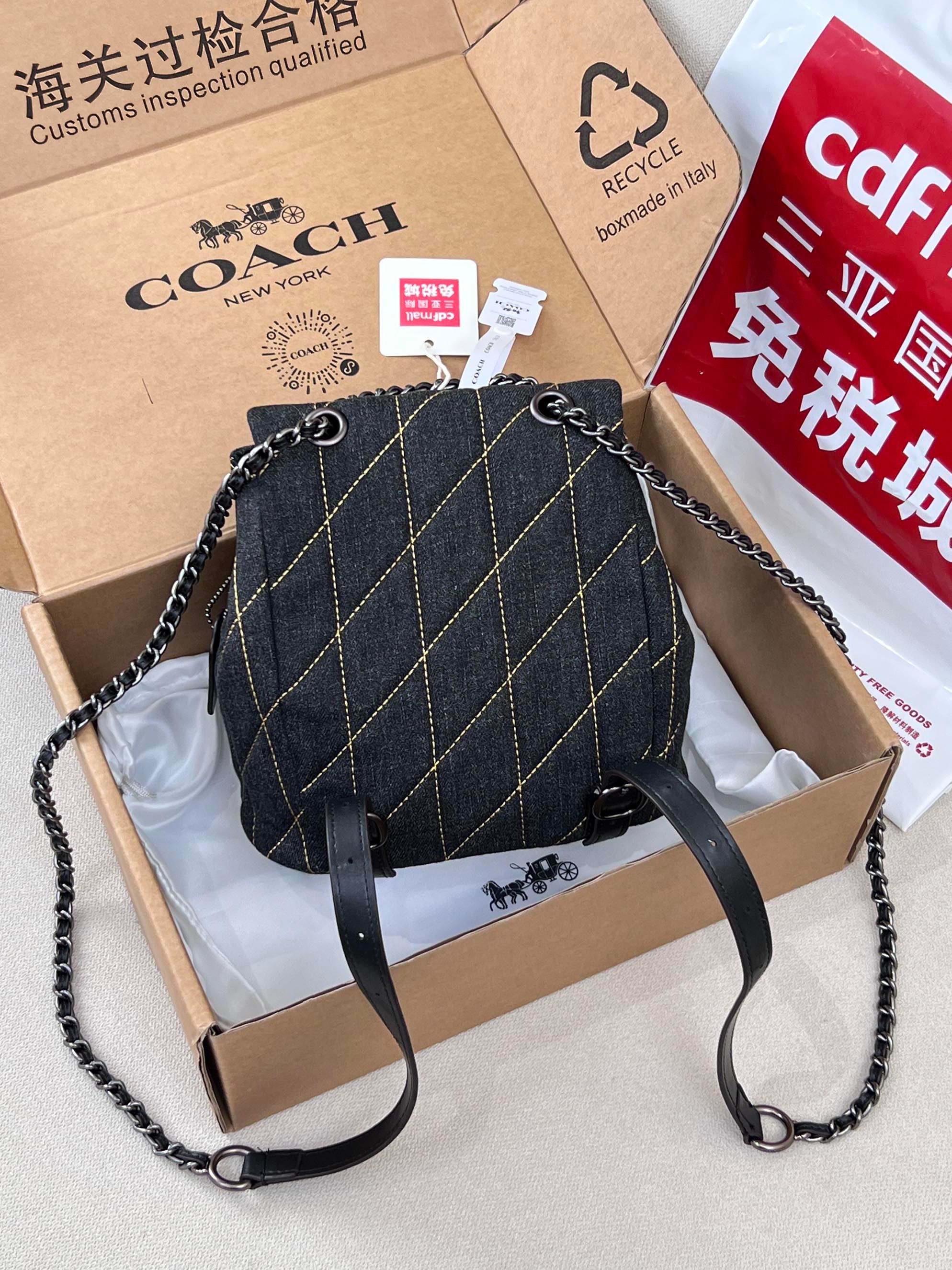 Coah bag dark denim bucket crossbody with chain and leather strap, flap front