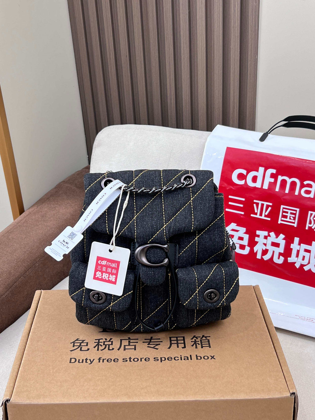 Coah bag dark denim mini crossbody with flap, front pocket, and metal ring