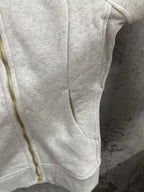 Light gray zip-up hoodie with gold zipper and side seam detail