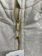 Close-up of gold zipper and metal pull on heather gray zip-up hoodie