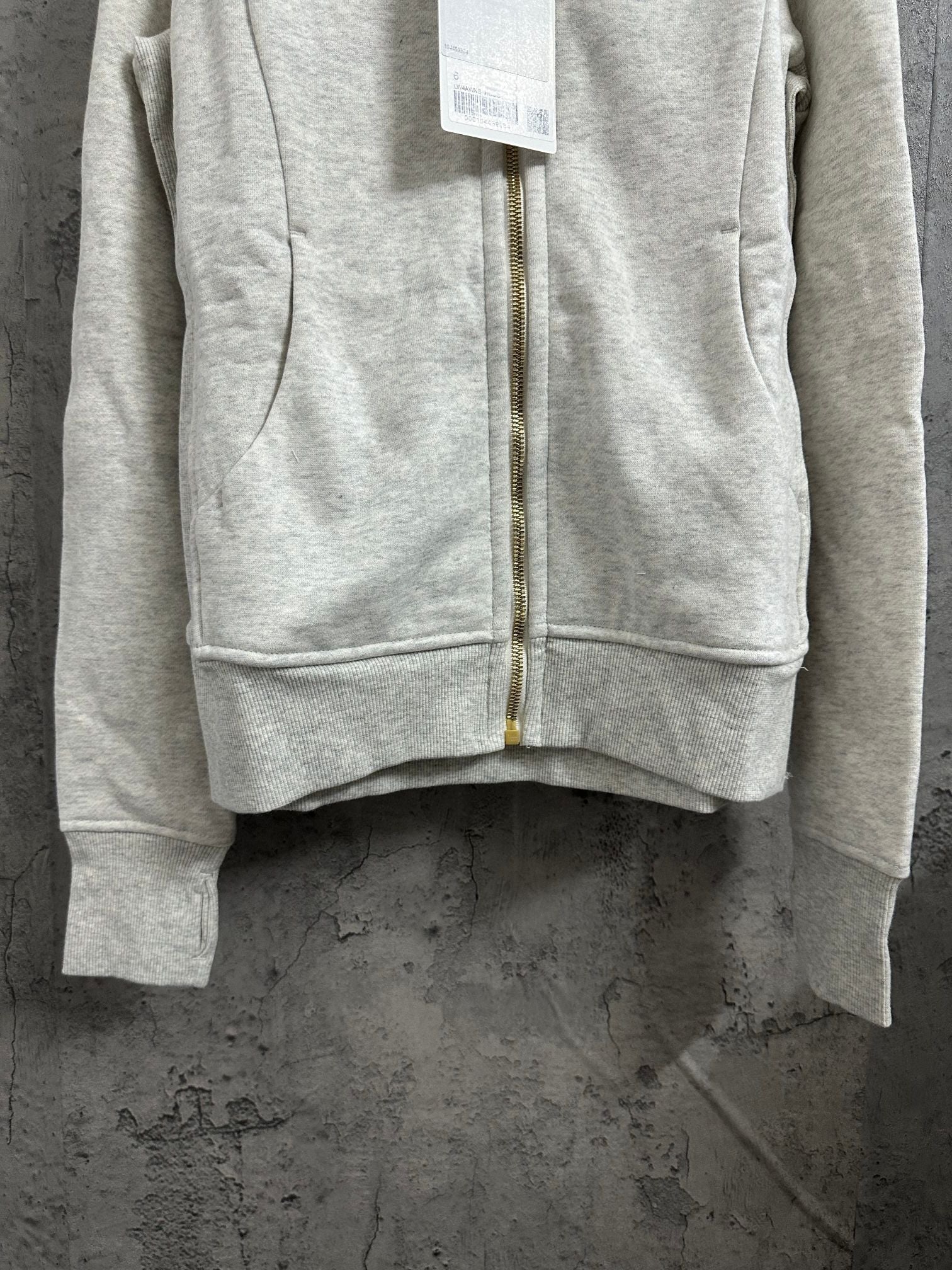 Light gray zip-up hoodie with gold zipper and kangaroo pocket seams