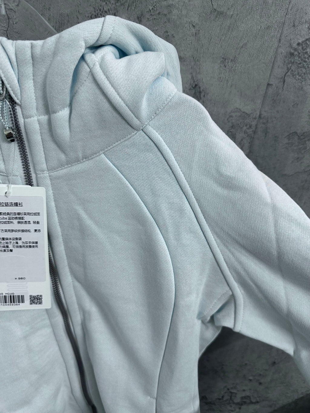 Light blue hoodie sleeve with hood and stitched panel seams