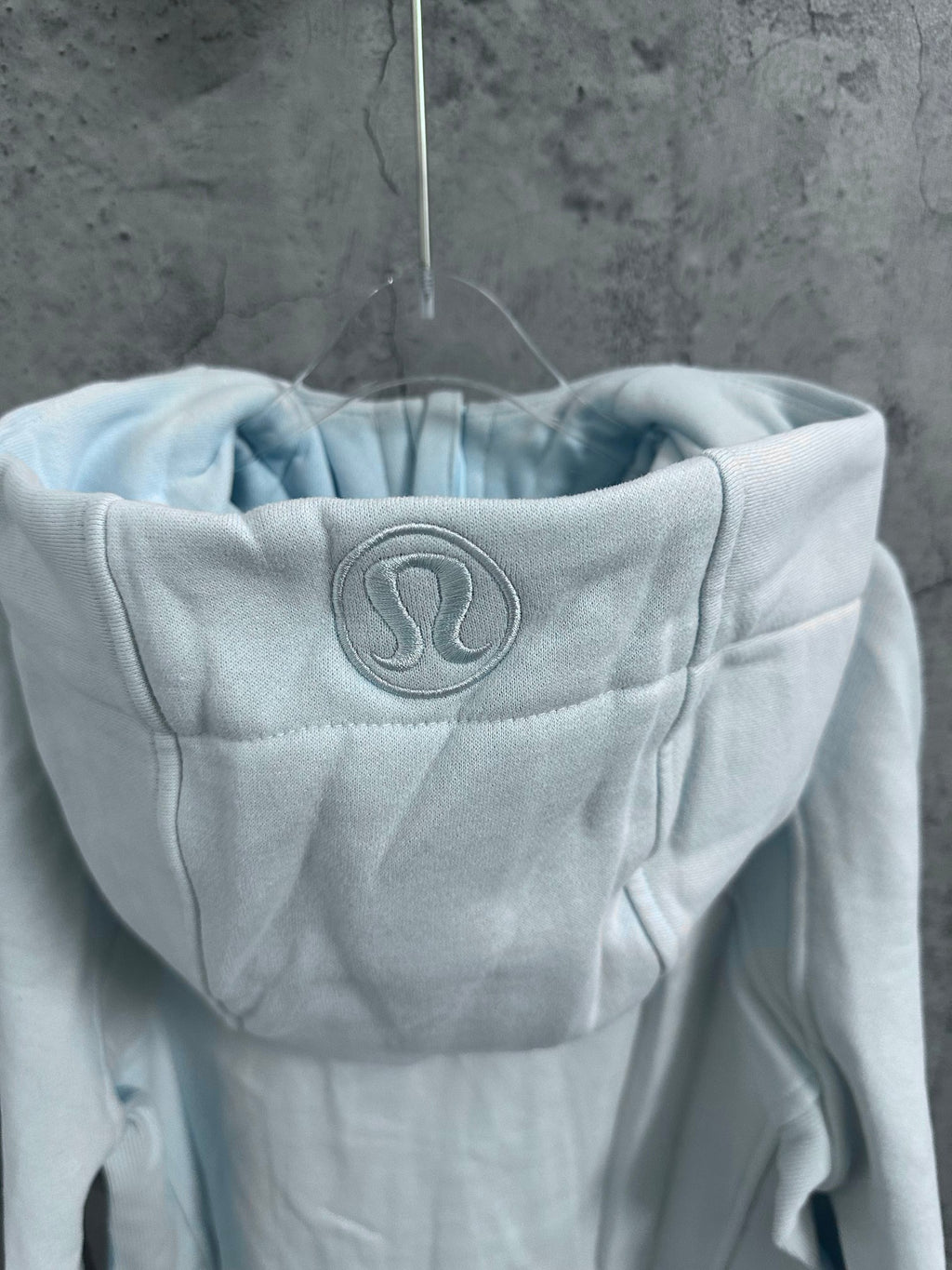 Light blue hoodie hood with embroidered logo patch
