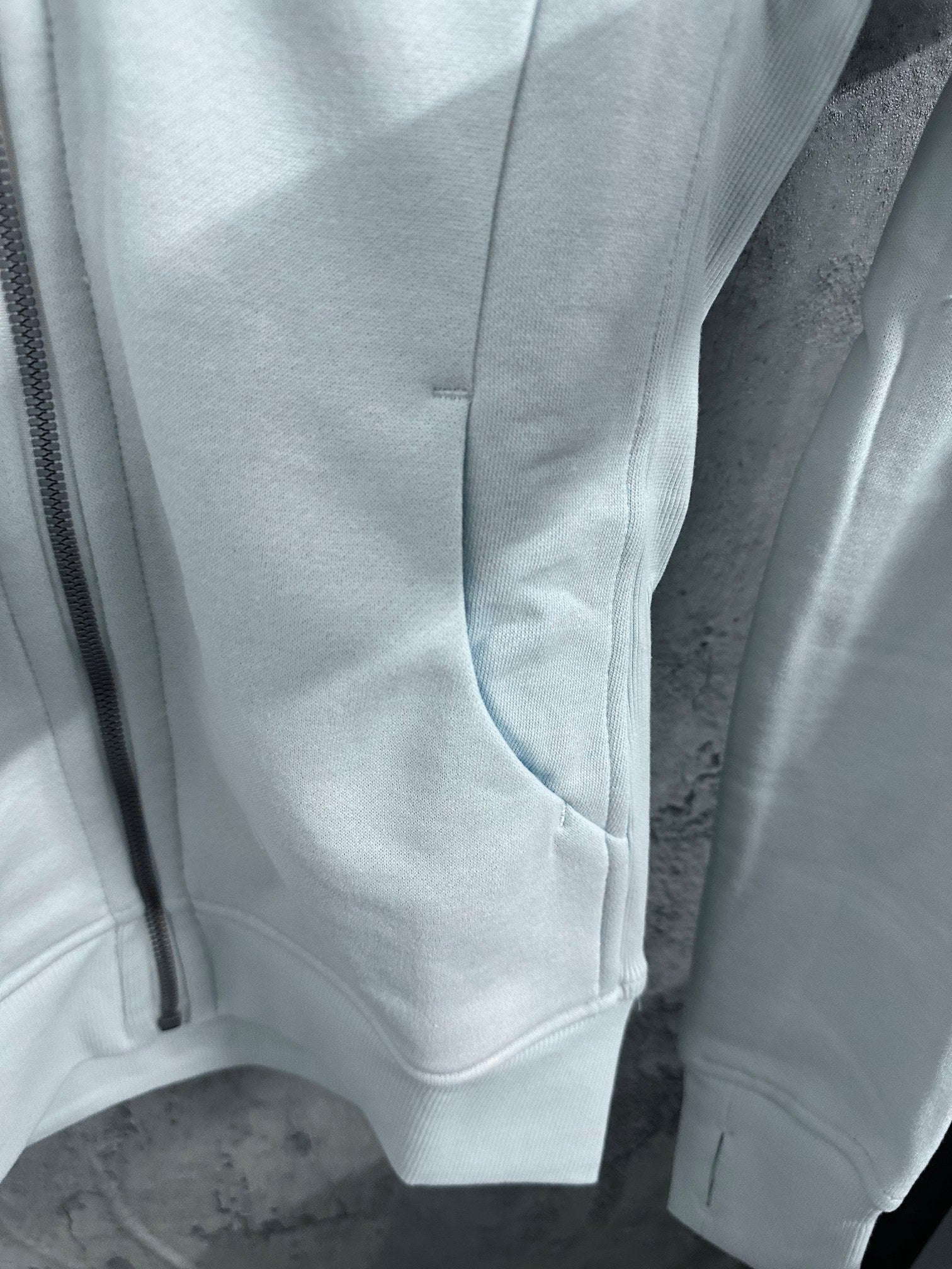 Light blue zip-up hoodie sleeve cuffs and front kangaroo pocket