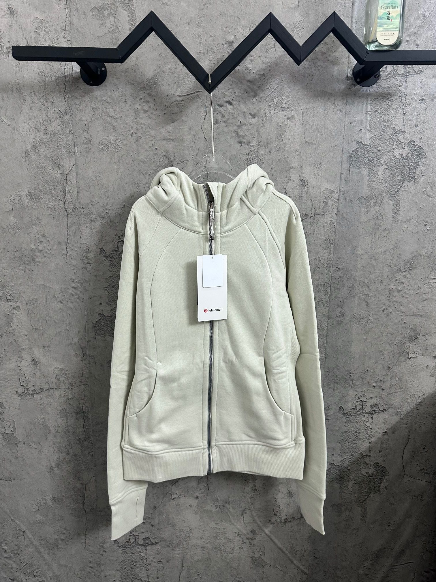 Off-white zip-up hoodie with hood and front zipper, quilted seam detail