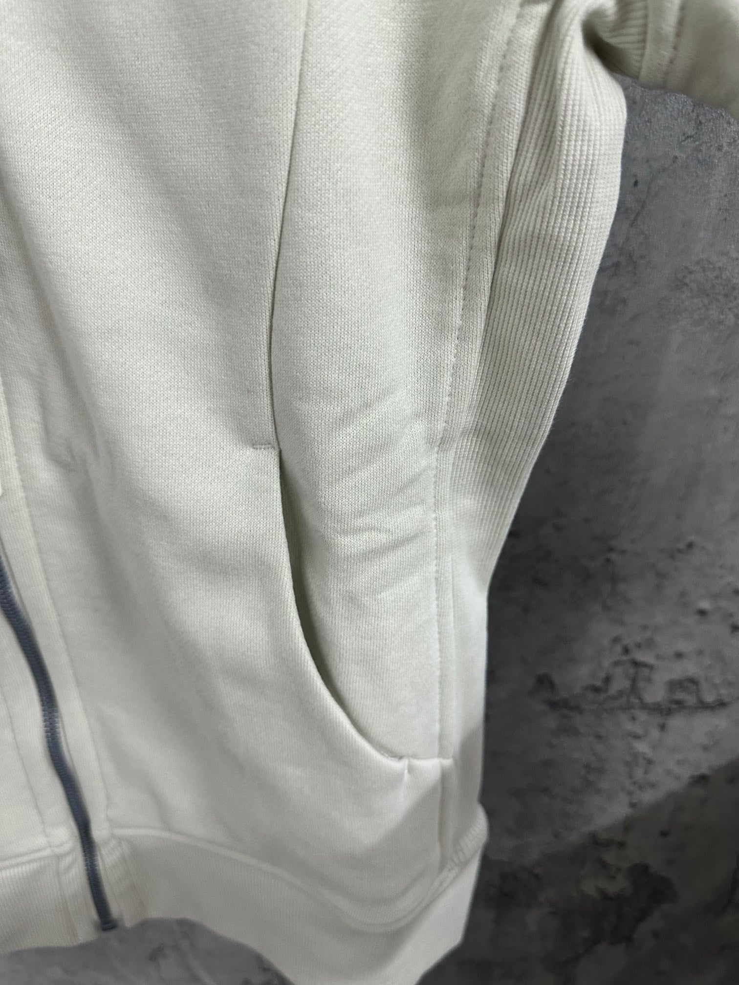 Light cream hoodie sleeve and front pocket seam detail