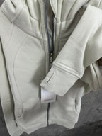 Off-white zip-up hoodie front with zipper and ribbed sleeve cuff