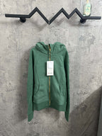 Green zip-up hoodie with hood, gold zipper, and front pouch pockets