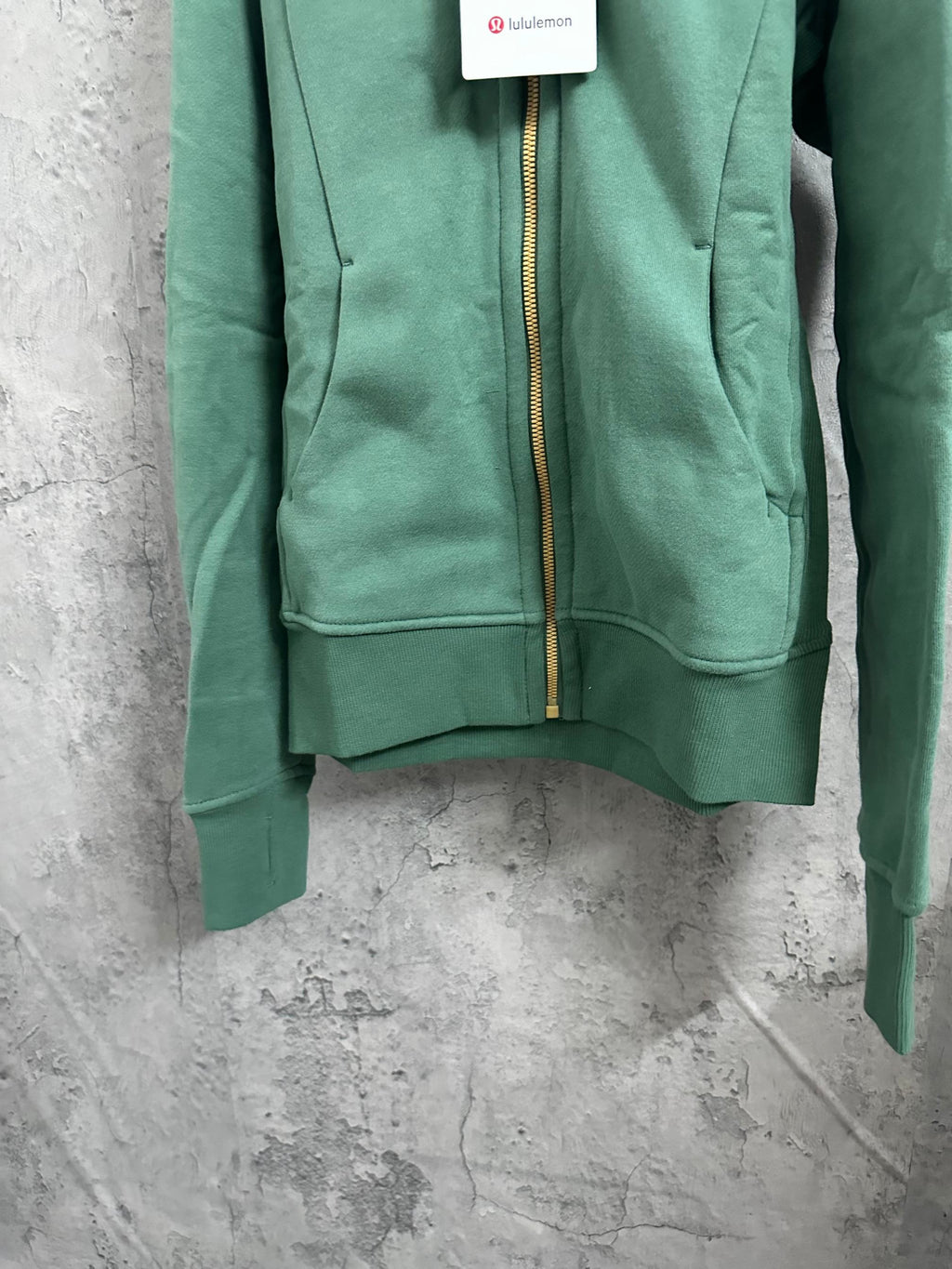 Green hooded zip jacket front view with gold zipper and kangaroo pocket