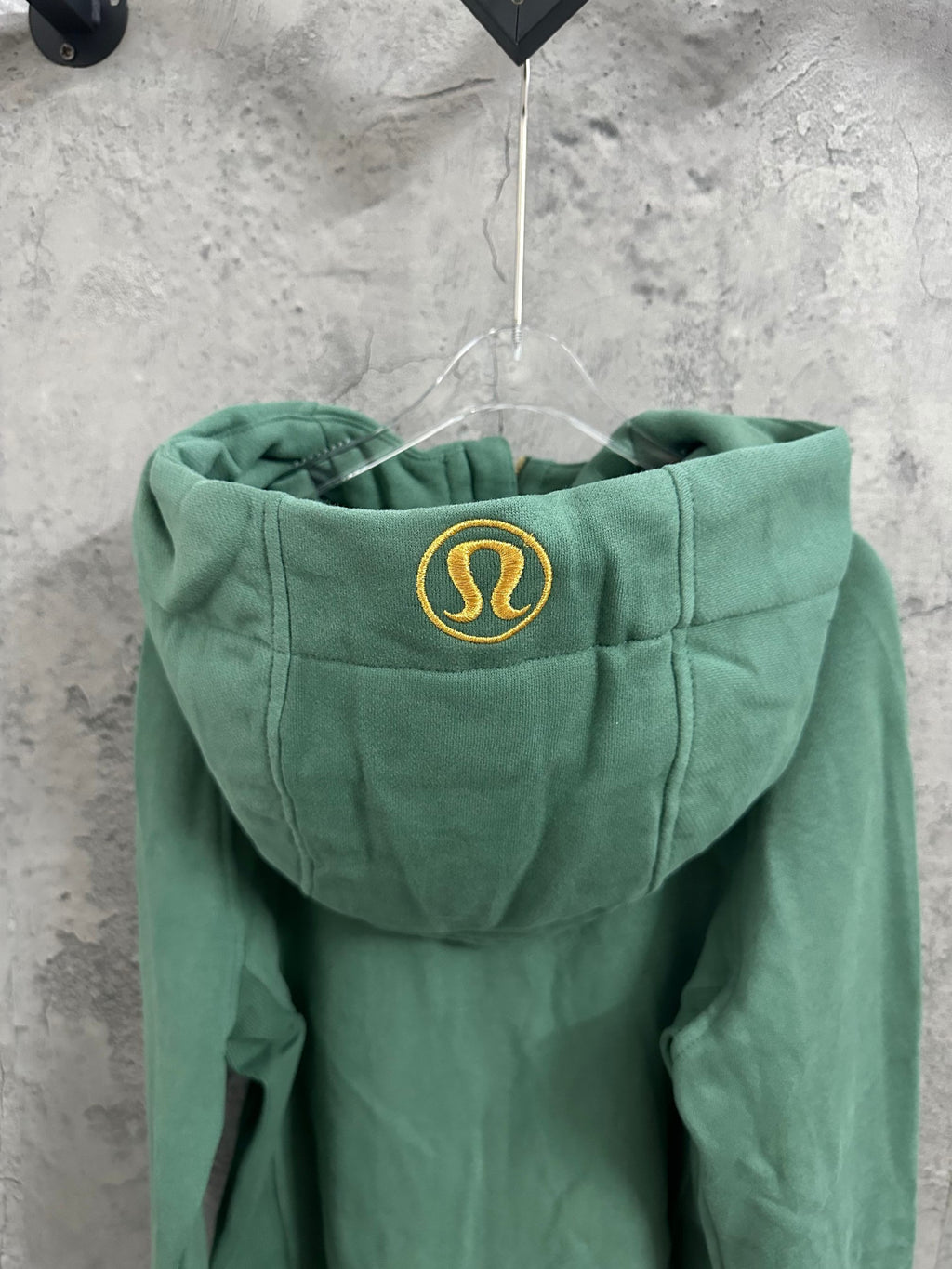 Green hoodie with hood featuring a yellow crest emblem