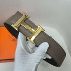 Taupe leather belt with gold H buckle and adjustable end with tab and stitching