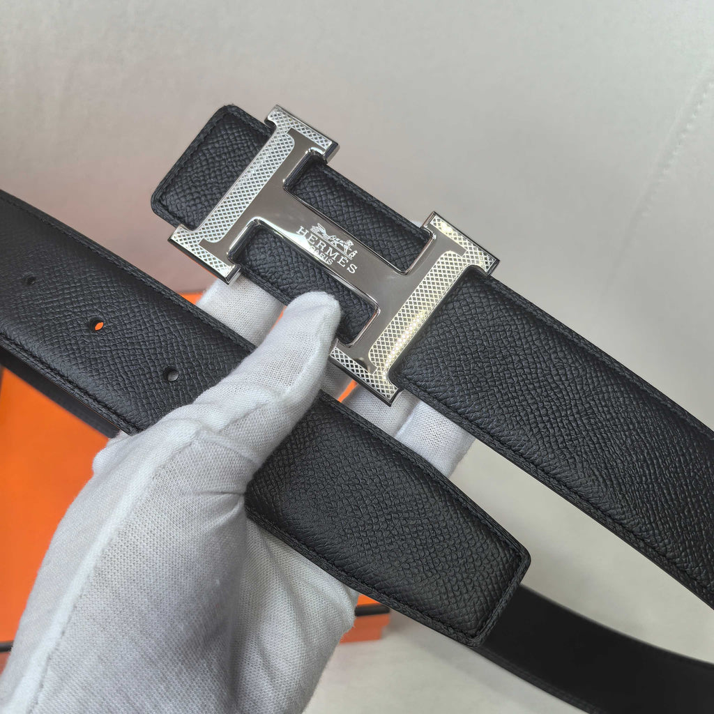 Black leather belt detail: silver Hermes buckle on textured strap