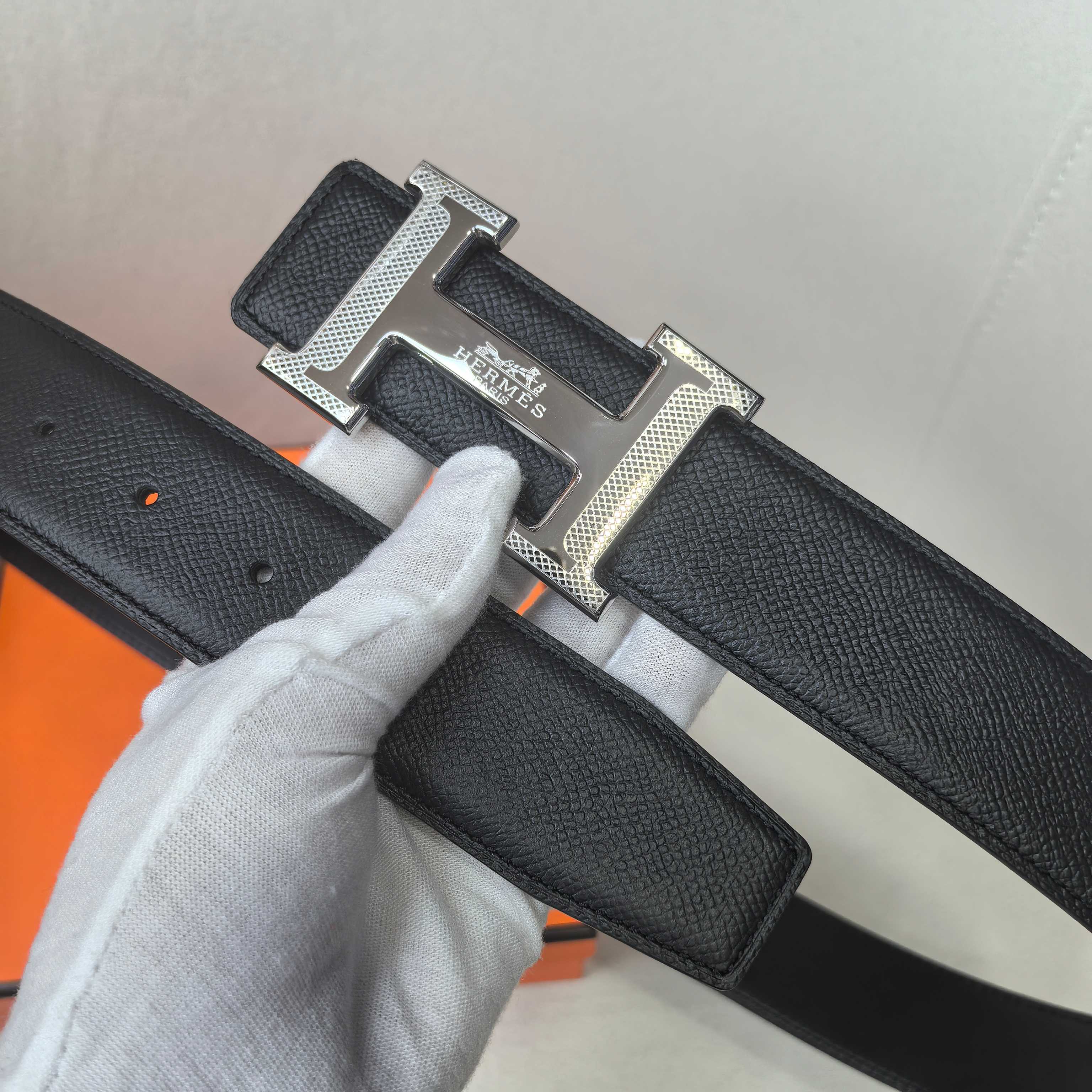 Black leather belt detail: silver Hermes buckle on textured strap