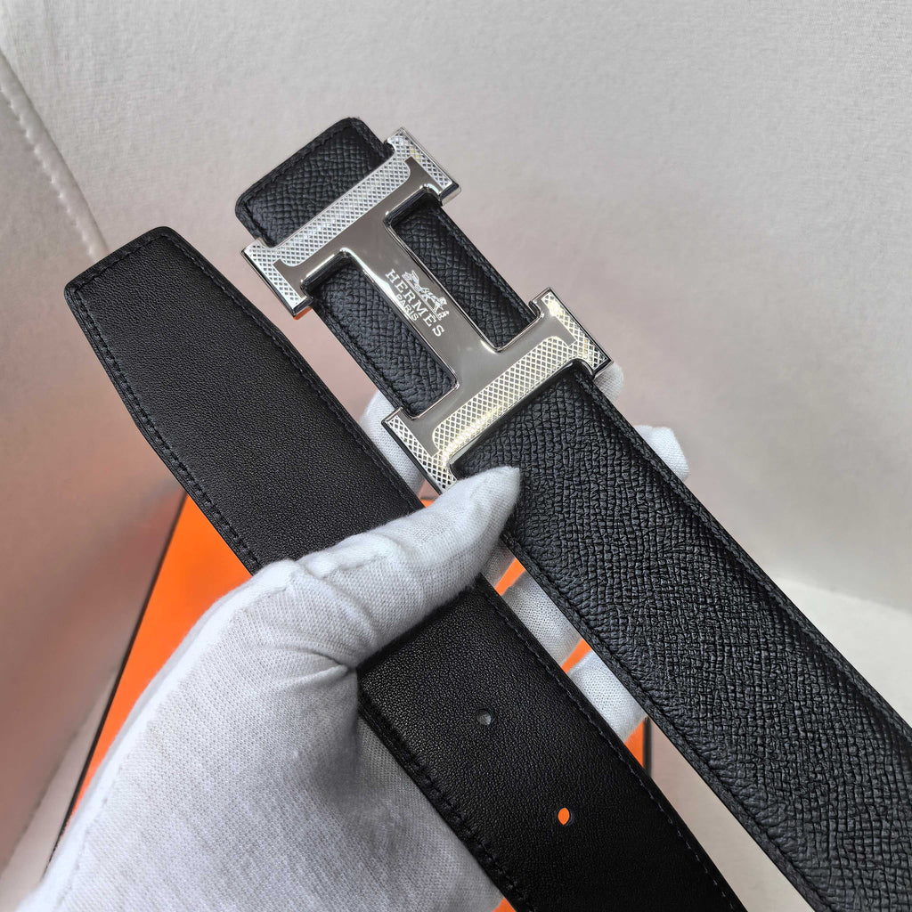 Black leather belt close-up of textured strap and silver buckle hardware
