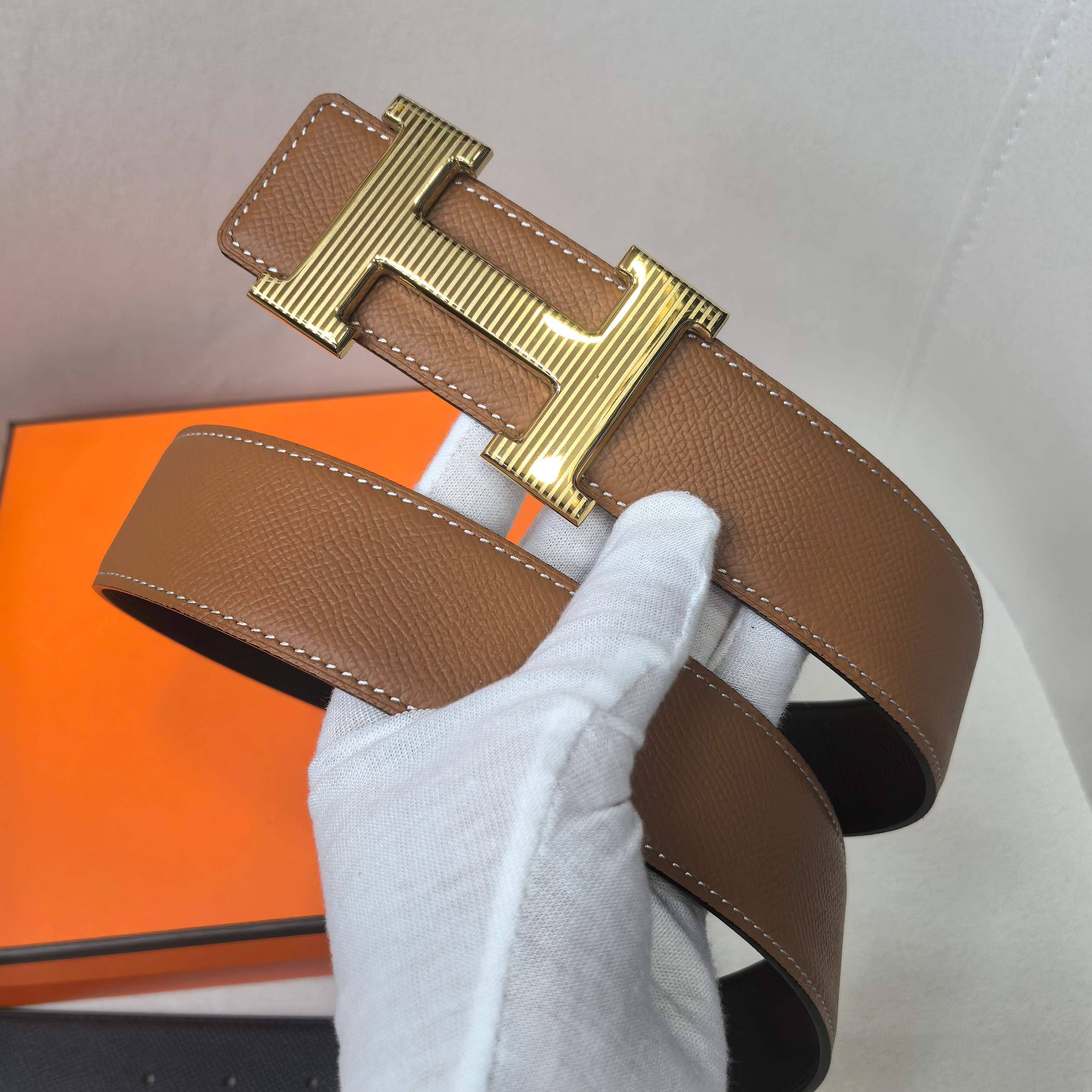 Brown leather belt with gold buckle and stitched tab ends