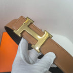 Brown leather belt with gold buckle, pebbled texture and stitched edge