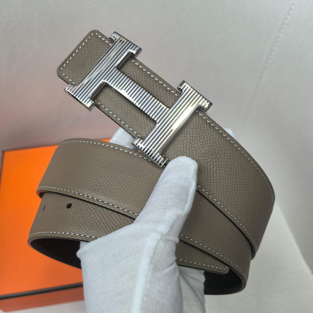 Leather belt with silver H buckle and taupe textured strap, white stitching