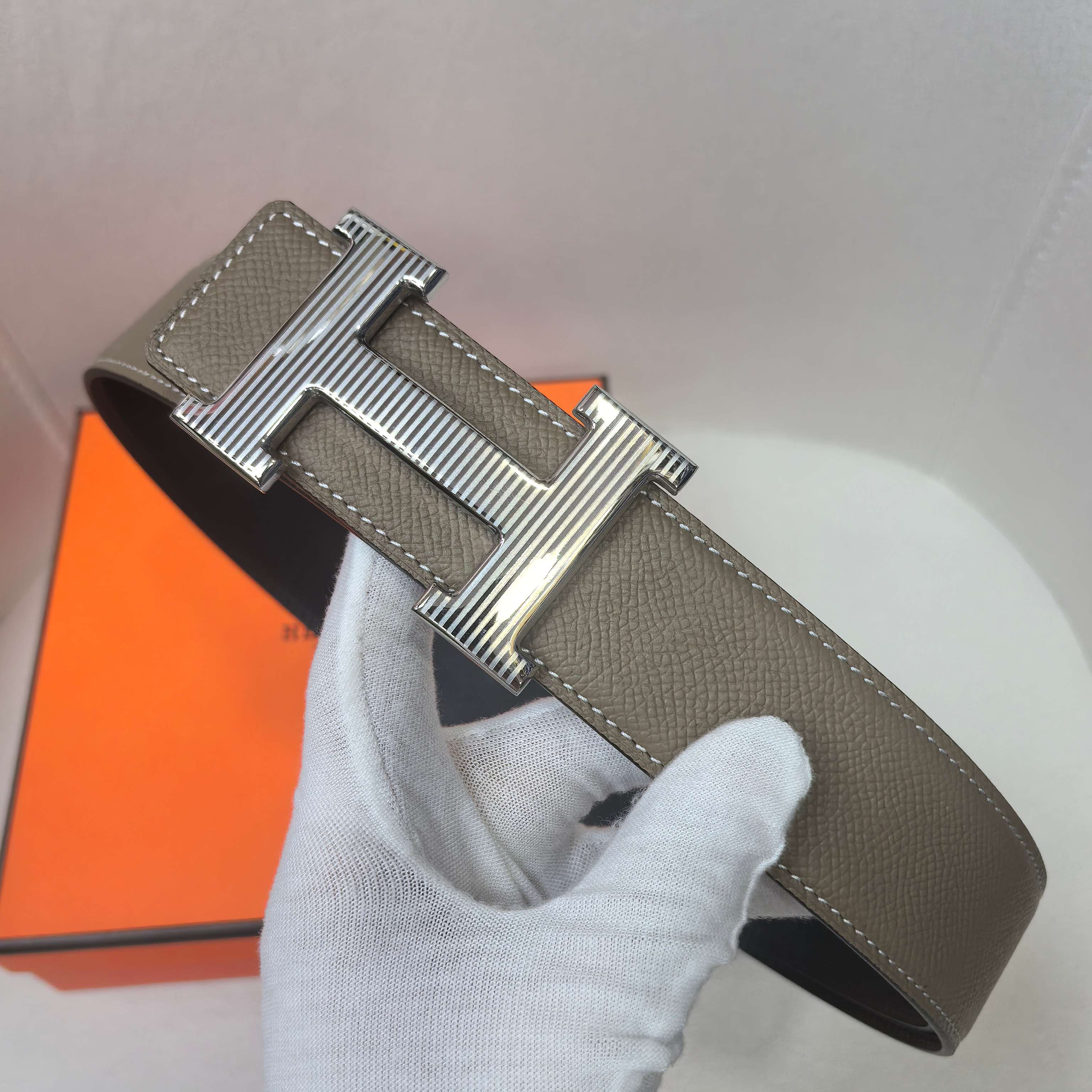 Leather belt with silver H buckle, taupe strap with visible edge stitching