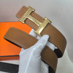 Brown leather belt close-up with gold buckle centerpiece and stitching