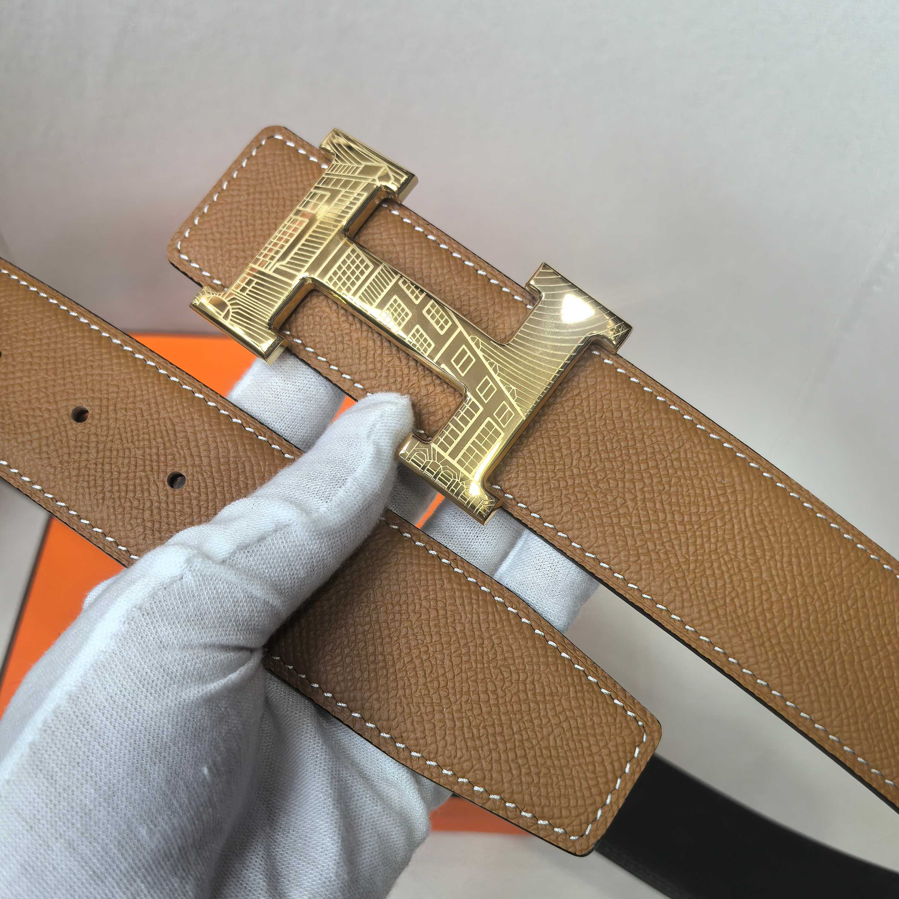 Brown leather belt detail with gold buckle and keeper tab
