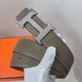 Brown leather belt with silver H buckle and contrast-stitched edges