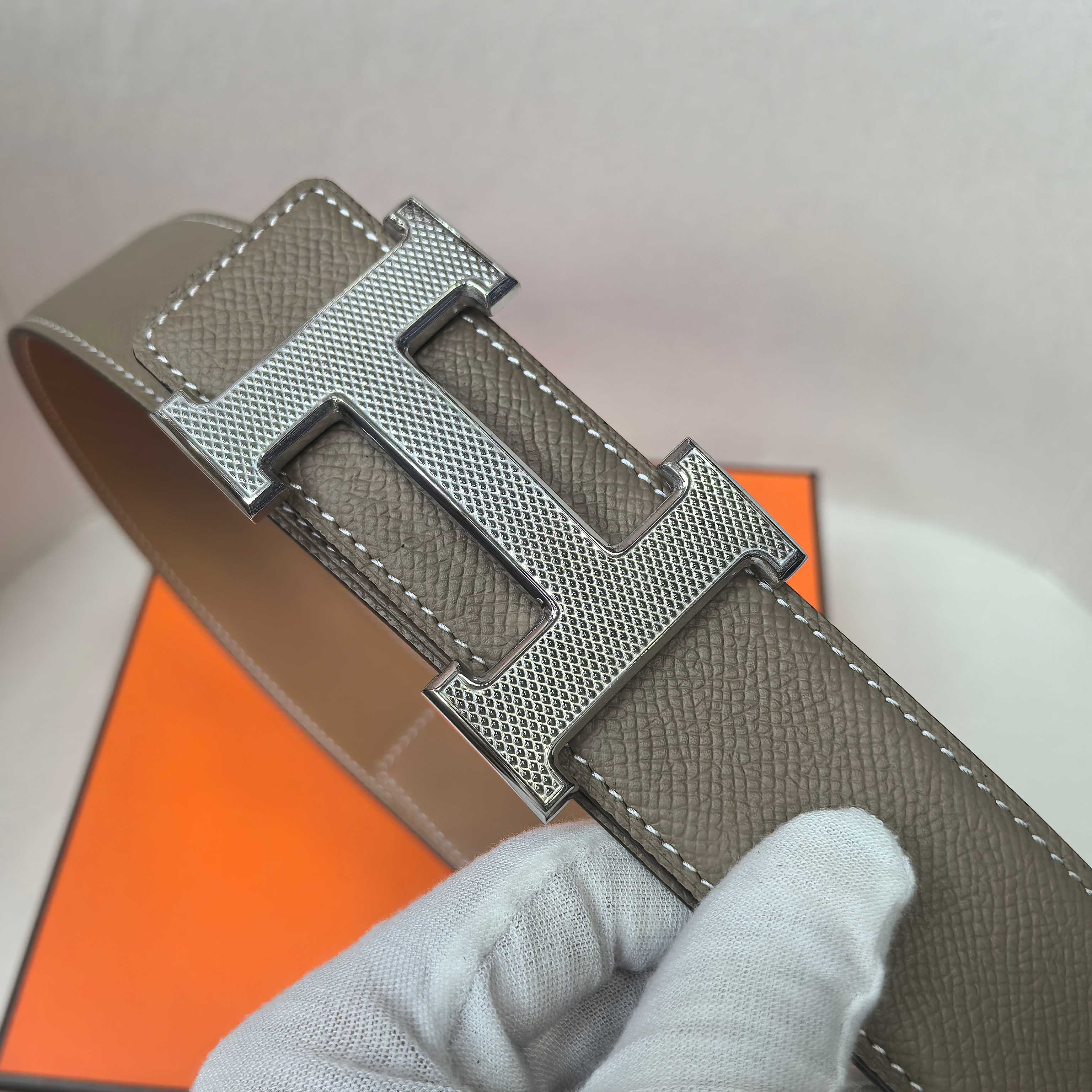 Brown leather belt with silver textured H buckle and stitched strap