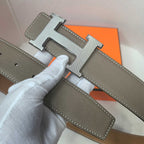 Brown leather belt with silver H buckle and textured strap end
