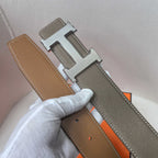 Brown leather belt with silver H buckle, lighter underside, and stitched edges
