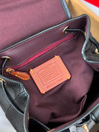 Coah mini backpack interior with burgundy lining, leather trim, and rectangular tag patch
