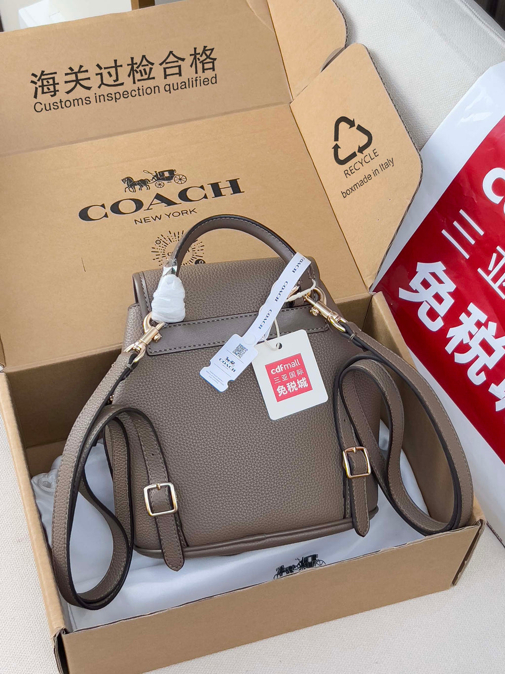 Coach mini backpack bag in taupe with flap, dual straps, and side pocket details