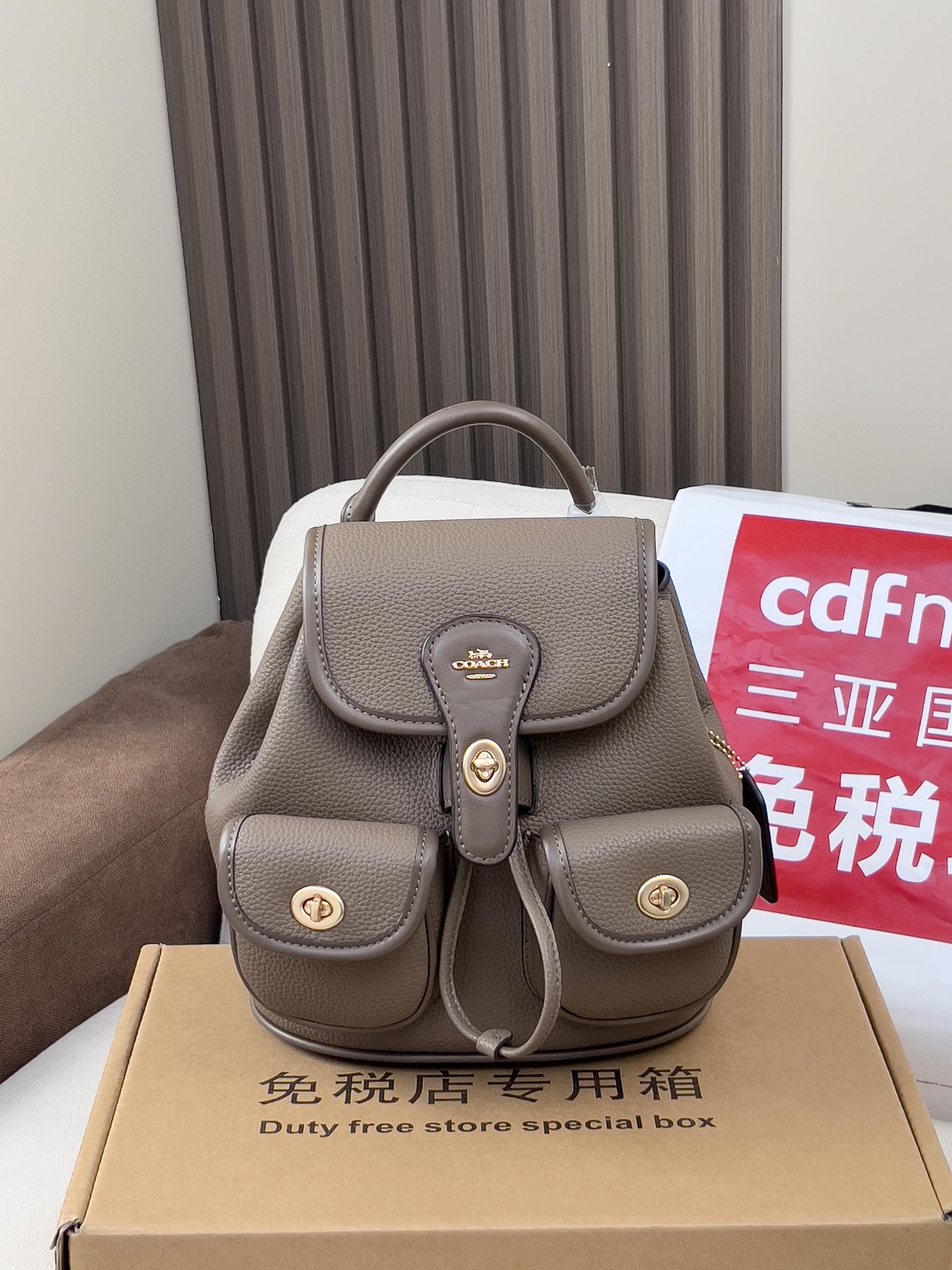 Coach mini backpack bag in taupe with top handle and front flap, small coin pocket