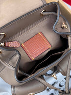 Coach mini backpack bag interior with leather patch and zip pocket, taupe lining