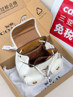 White mini backpack bag open with tan interior and adjustable shoulder straps