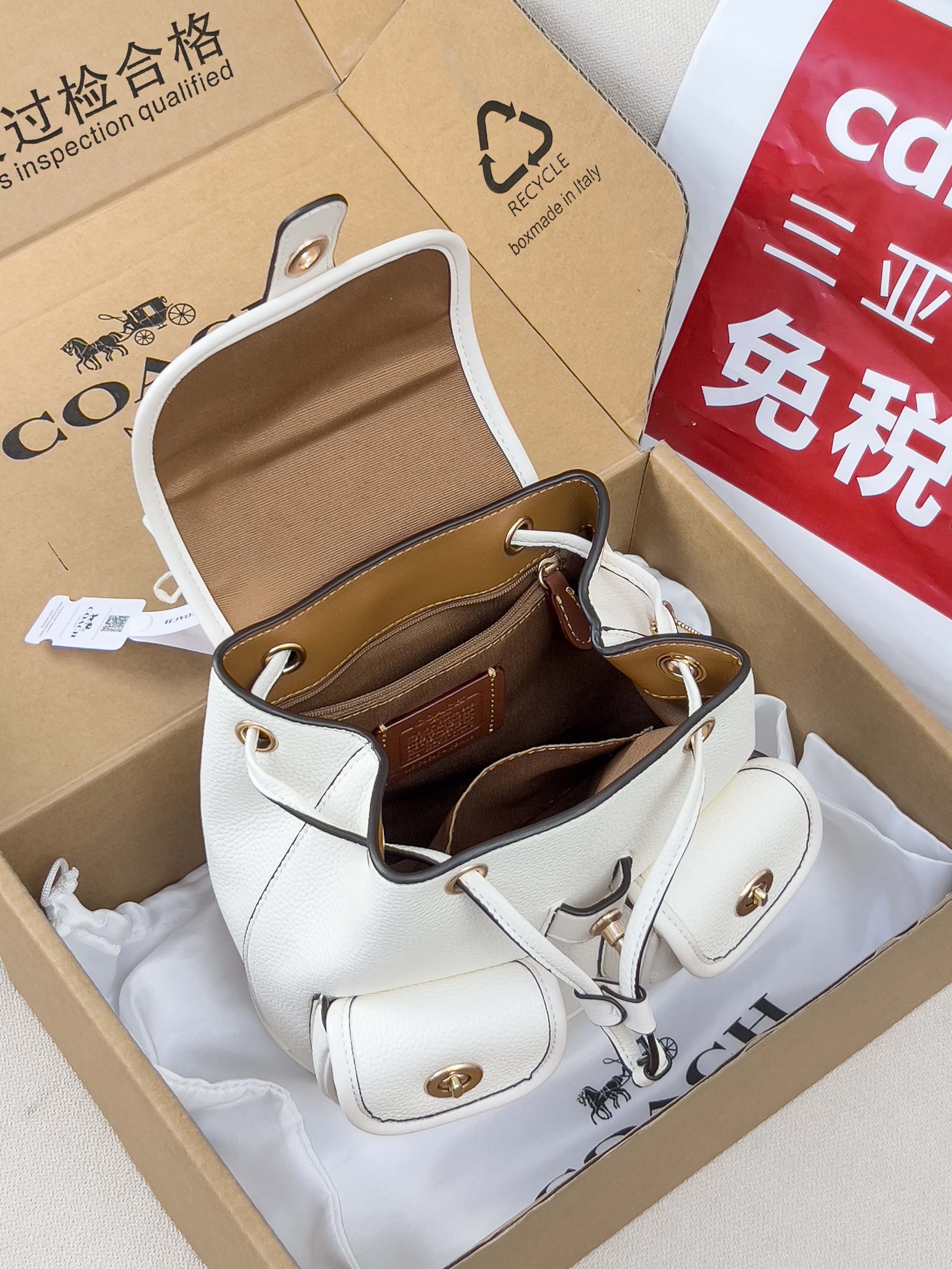 White mini backpack bag open with tan interior and adjustable shoulder straps
