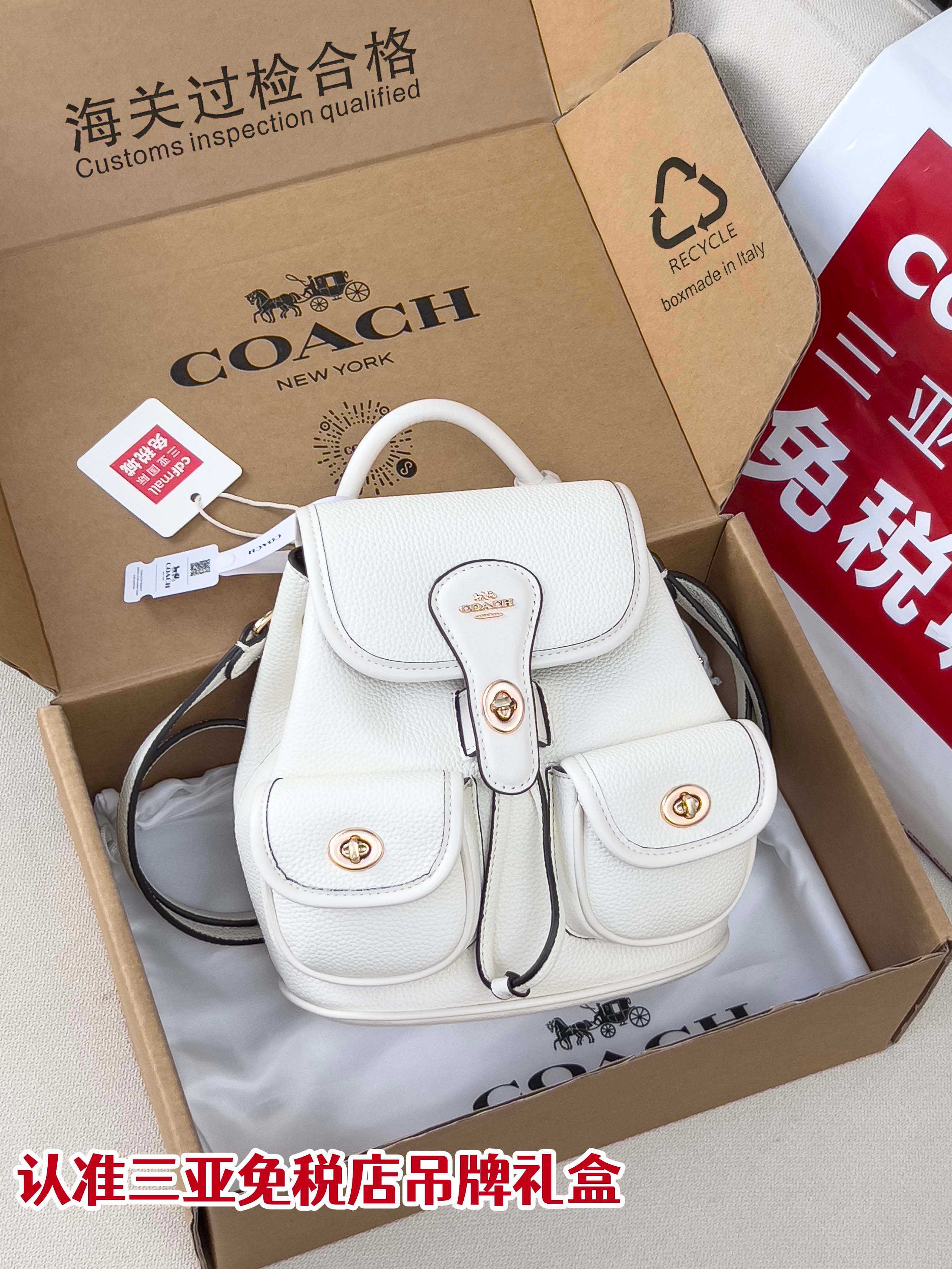 White mini backpack bag with flap front, top handle, and drawstring tie