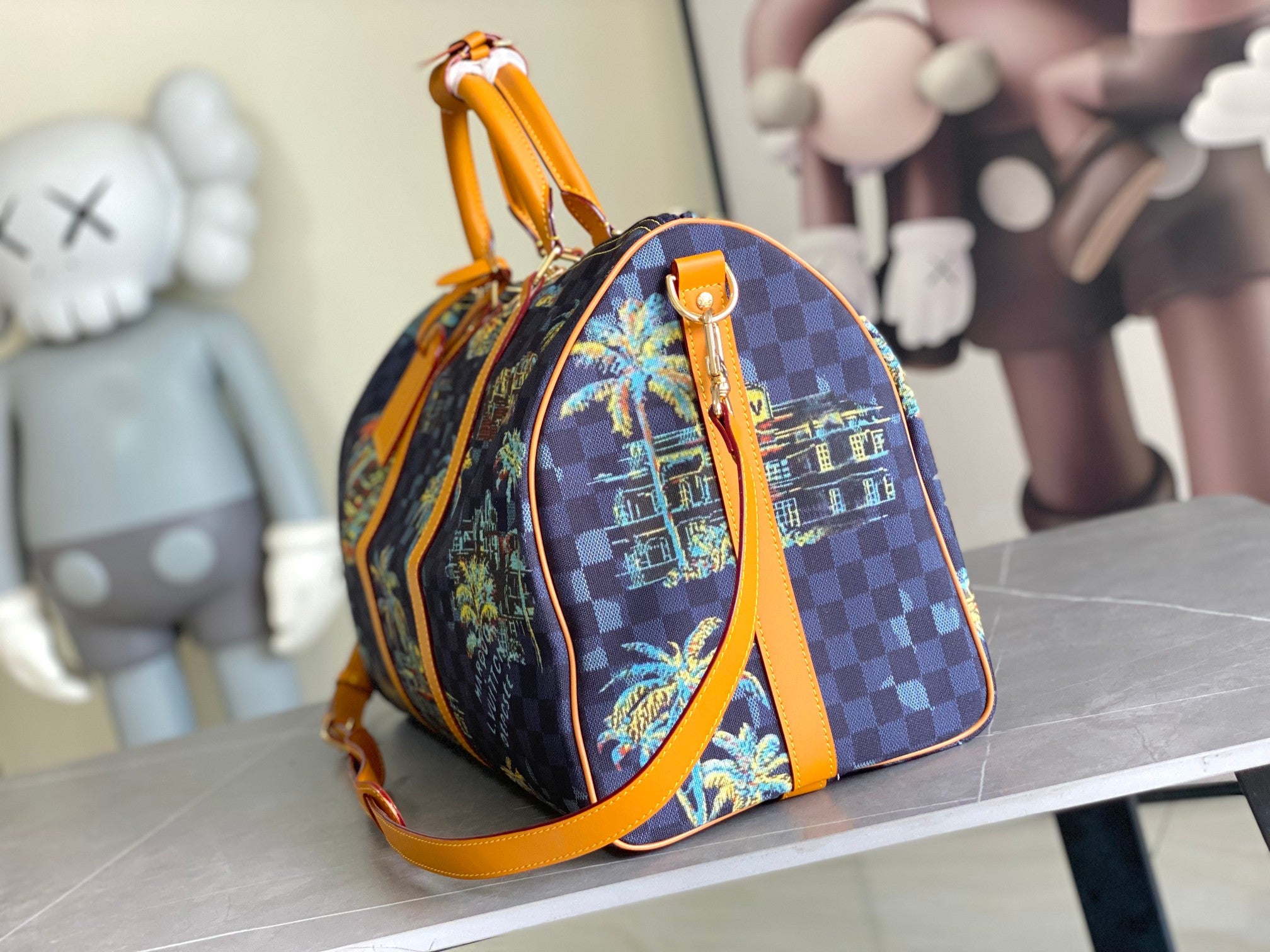 Louis Vuitton handbag with dark navy check pattern, colorful graphic panel, and orange top handle.