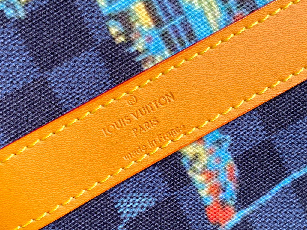 Orange leather trim with embossed “LOUIS VUITTON” text and yellow contrast stitching.