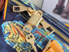 Gold zipper hardware on navy printed canvas with orange edging and colorful motif detail.