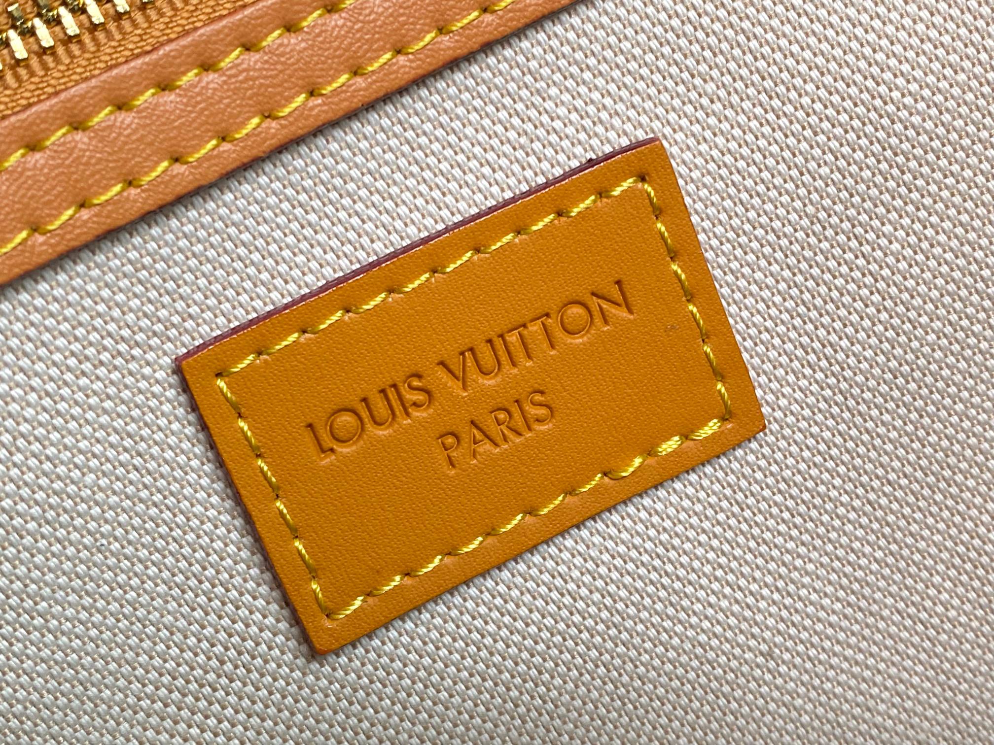 Beige canvas label with “LOUIS VUITTON PARIS” text on orange leather patch.