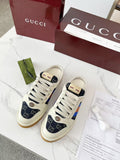Gucci low-top sneakers with white laces, navy GG canvas, and multicolor stripe detail