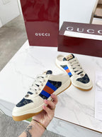 Gucci low-top sneakers held up, cream laces with navy GG canvas and blue-red stripe