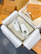 White Louis Vuitton trainer shoes with layered sole and lace-up front.