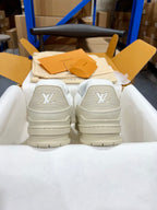 White Louis Vuitton trainer shoes with LV logos on the back heels.
