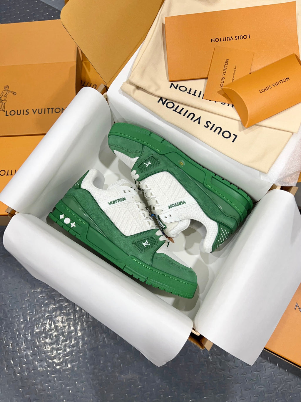 Green-and-white Louis Vuitton trainer viewed from side, LV tongue logo and lace trim