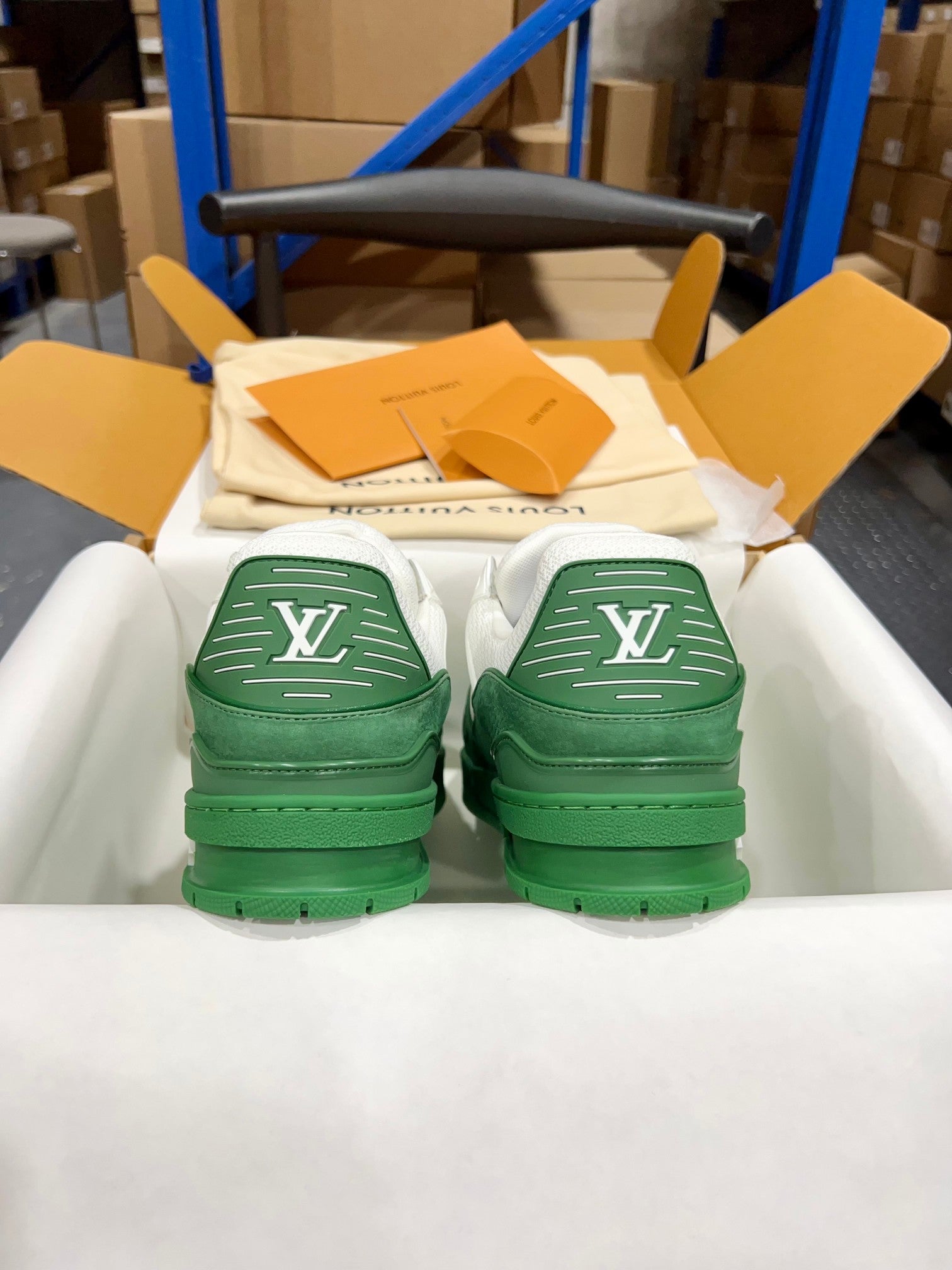 Green Louis Vuitton trainer pair viewed from back, stitched LV markings on heels